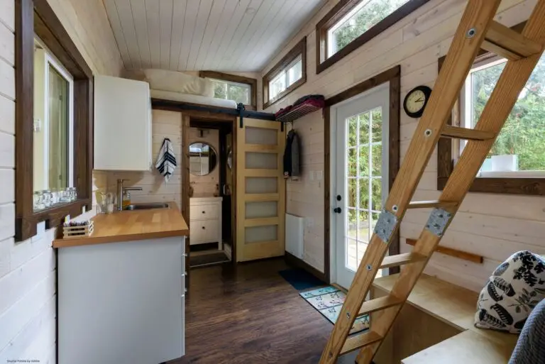 Inneneinrichtung eines Esszimmers und einer Küche in einem winzigen rustikalen Blockhaus.