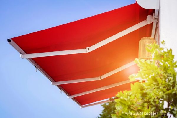 Rote Markise bietet sommerlichen Wärmeschutz.