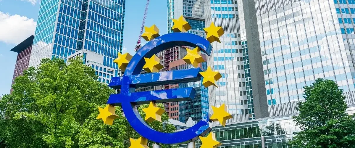 Featurebild für Europa: Euro-Symbol mit Sternen und EU-Gebäuden,